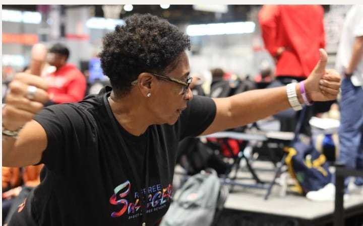 Violet Palmer giving a thumbs up in a crowded gym